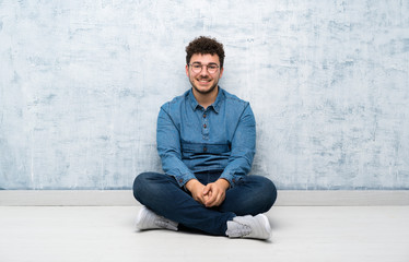 Young man sitting on the floor with glasses