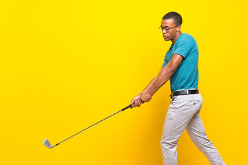 Afro American golfer player man over isolated yellow background