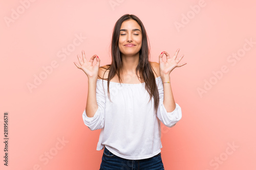 Cuadros en Lienzo Young woman over isolated pink background in zen pose