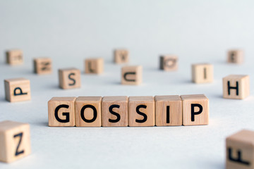 Wall Mural - Gossip - word from wooden blocks with letters, other people’s private lives concept, random letters around, top view on wooden background