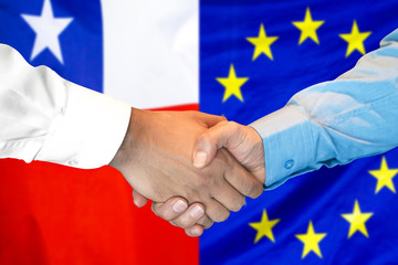 Wall Mural - Business handshake on the background of two flags. Men handshake on the background of the Chile and European Union flag. Support concept