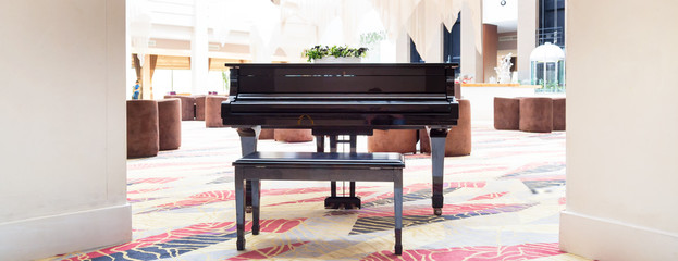 Piano in an empty spacious room. An old piano stands in the lobby of a large hotel.