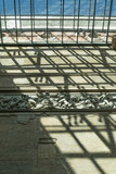 Fototapeta Miasto -  Upwards perspective of the shadow patterns coming from the roof of the Berlin's Museum Island, Neues Museum, and an exhibition of statues into the wall