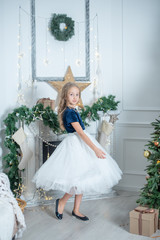 Wall Mural - portrait of a girl in Christmas decorations. child enjoy the holiday near Christmas tree. 