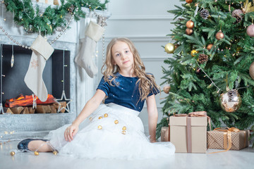 Wall Mural - portrait of a girl in Christmas decorations. child enjoy the holiday near Christmas tree. 