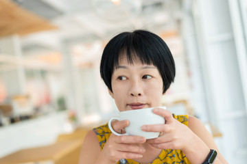 Poster - Asian woman hold a cup of coffee