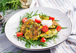 Zucchini pancakes with corn and sour cream served arugula, tomatoes salad.