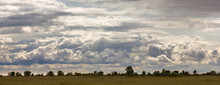 Huge Cumulus Rain Clouds And Clouds In The Sky In The Sunshine Above The Field Panorama 