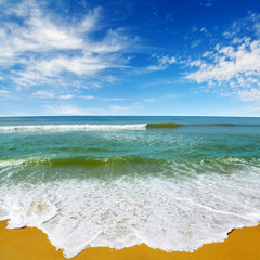Wall Mural - Ocean waves, yellow sand, azure sea.