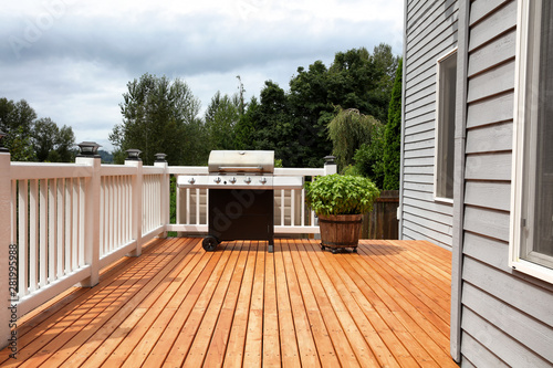 Cuadros en Lienzo Barbecue grill cooker with wooden barrel of fresh basil on open outdoor deck