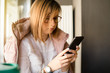 © Miljan Živković - Young woman using smart mobile phone at the cafe checking messages sending waiting for the call
