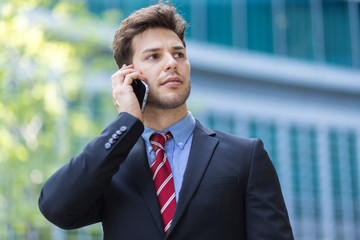 Young manager on the phone outdoor in an urban setting