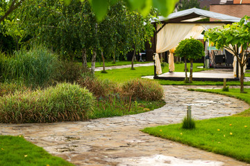 Wall Mural - path made of natural stone among trees in landscaping