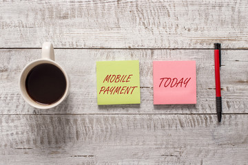 Word writing text Mobile Payment. Business photo showcasing Cashless Payment made through portable electronic devices Stationary placed next to a cup of black coffee above the wooden table