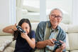 © Creativa Images - Cheerful child playing video games with grandfather