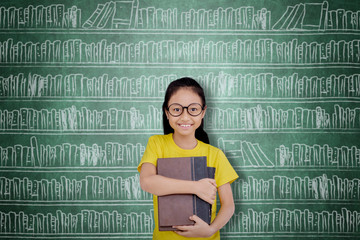 Wall Mural - Happy female student holding books in the library