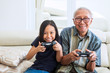 © Creativa Images - Senior man playing video games with his grandchild