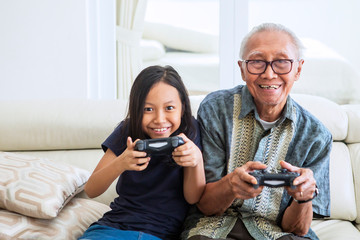 Wall Mural - Senior man playing video games with his grandchild