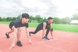 © TeTe Song - Two sportsman runners on starting position ready for competition in running at the stadium..