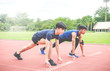 © TeTe Song - Two sportsman runners on starting position ready for competition in running at the stadium..
