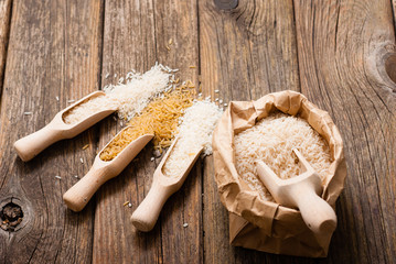 Wall Mural - different types of rice on scoops, old wood table