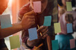 © successphoto - Asian business hand holding note paper meeting with new startup project use post it notes to share idea discussion and analysis data charts and graphs.Business finances and accounting concept