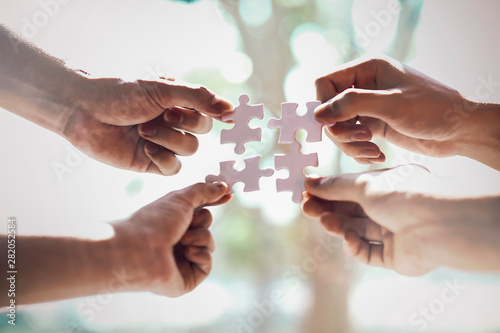 Fotografía Closeup hand of business people connecting jigsaw puzzle with sunlight effect, B