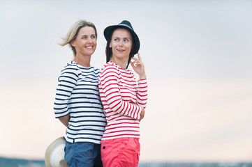 Two young women have fun together on stormy seaside