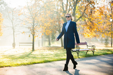 Wall Mural - middle-aged woman walking in city park