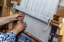 Carpet Weaving Close Up. Senior Woman's Hand Weaves Traditional Manual Silk Carpet Loom