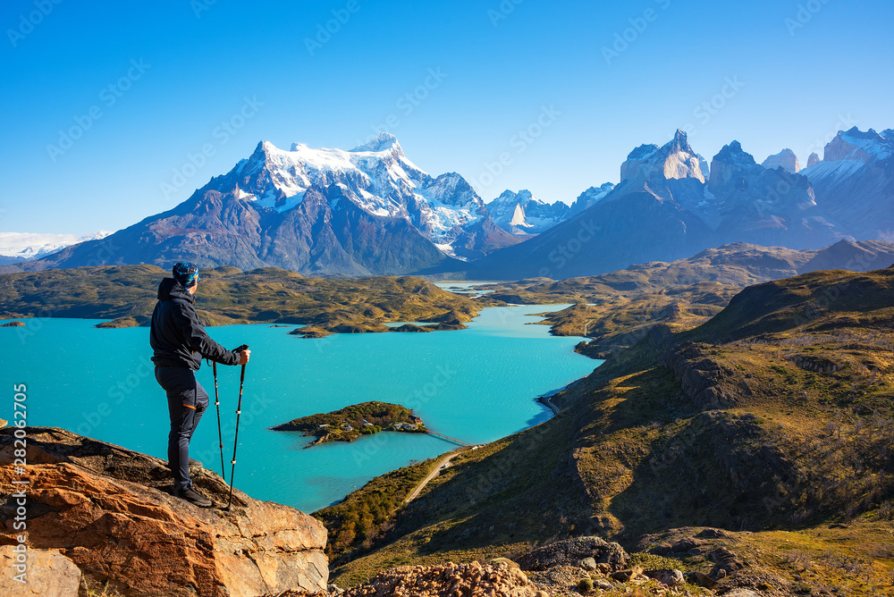 Hiker at mirador condor enjoying amazing view of Los Cuernos rocks and Lake Pehoe in Torres del Paine national park, Patagonia, Chile - obrazy, fototapety, plakaty 