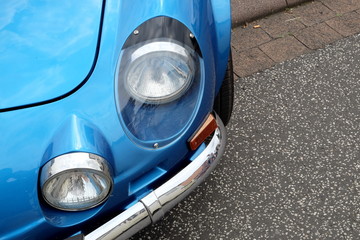 Wall Mural - Scheinwerfer eines blauen französischen Heckmotor Sportwagen der Sechzigerjahre und Siebzigerjahre im Sommer beim Oldtimertreffen Golden Oldies in Wettenberg Krofdorf-Gleiberg bei Gießen in Hessen