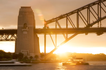 Close-up view of people climbing the Sydney Harbour Bridge at sunset