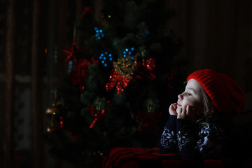 Little girl in red hat waiting for santa