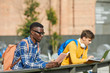 © Seventyfour - Portrait of African-American student reading book outdoors in sunlight, copy space