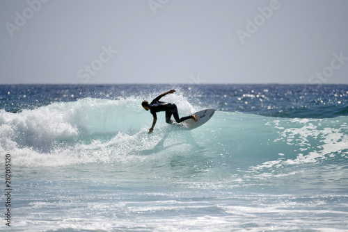 Fotomural Young pro surfer surfs a big barrel wave in popular surf spot in breathtaking