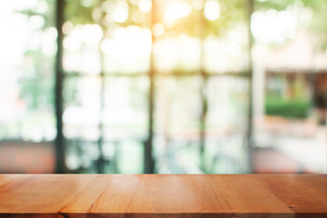 Wall Mural - wooden table with blurred of coffee's shop for abstract background