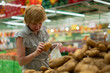 © Mihail - adult woman in the grocery store making food purchases