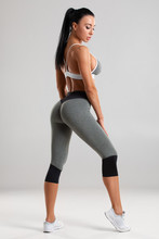 Beautiful Athletic Girl, Sexy Fitness Woman In Leggings On The Gray Background