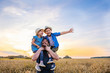 dad holds two children in his arms. happy family playing in the field in the evening sunset.