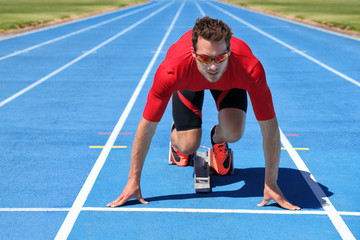 Wall Mural - Sport athletics track and field stadium fitness athlete starting race at running tracks ready to run. Runner man going running outside on blue track lanes.