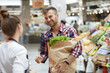 © Seventyfour - Waist up portrait of handsome young man talking to sales assistant while grocery shopping in supermarket, copy space