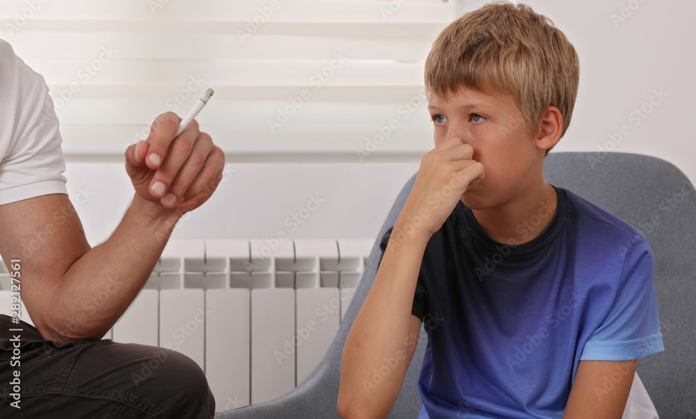 Stop smoking near children. Father smoking cigarette , boy disgusted by  smoke Stock Photo