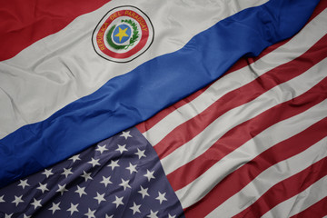 waving colorful flag of united states of america and national flag of paraguay.