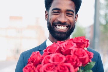 Wall Mural - Beautiful happy man outside in the park with roses