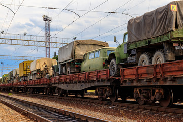 Wall Mural - Cargo train carrying military vehicles on railway flat wagons