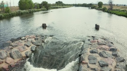 Canvas Print - River flowing through a dam structure with a boat chute and surfing wave - South Platte River below Denver, Colorado - aerial view