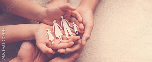 Fotomural Adult and children hands holding paper family cutout, family home, foster care,