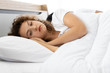 © tuaindeed - Upset depressed young woman lying on the bed against his husband. Relationship difficulties.