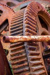  Large abandoned machine cogs are left to rust and decay in a junkyard.